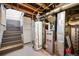 Basement area with essential utilities, including a water heater and HVAC system at 5115 Osceola St, Denver, CO 80212