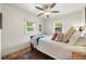 Bright bedroom with hardwood floors, comfy rug, and natural light from two windows at 5115 Osceola St, Denver, CO 80212