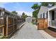 Long driveway leading to a detached garage, framed by wooden fences and greenery at 5115 Osceola St, Denver, CO 80212