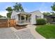 Charming home with a welcoming front porch, complemented by lush greenery and landscaping at 5115 Osceola St, Denver, CO 80212