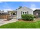 Cozy home with a well-kept lawn, complemented by a charming porch and mature landscaping at 5115 Osceola St, Denver, CO 80212