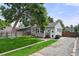 Charming home exterior with a well-maintained lawn, gravel driveway, and a detached garage at 5115 Osceola St, Denver, CO 80212