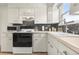 Clean kitchen with white cabinets, a gas range, and ample counter space at 5115 Osceola St, Denver, CO 80212
