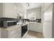 Well-lit kitchen with white cabinetry and a black tile backsplash at 5115 Osceola St, Denver, CO 80212
