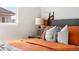 Bedroom decor featuring a modern bed with vibrant orange bedding, bedside lamps, and stylish decor at 10565 Wildhurst Cir, Highlands Ranch, CO 80126