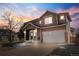 Charming two-story home with a two car garage, beautiful landscaping, and warm exterior lights at 10565 Wildhurst Cir, Highlands Ranch, CO 80126