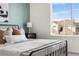 Light and airy main bedroom with a black metal bed frame and large window view at 10565 Wildhurst Cir, Highlands Ranch, CO 80126