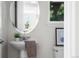 Cozy powder room with a pedestal sink, decorative mirror, and neutral tones for a serene atmosphere at 10565 Wildhurst Cir, Highlands Ranch, CO 80126