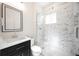 Modern bathroom featuring marble-tiled shower with glass door, sleek vanity, and contemporary fixtures at 4059 Quivas St, Denver, CO 80211