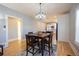 Stylish dining area featuring hardwood floors, a contemporary chandelier, and seamless flow to the kitchen at 4059 Quivas St, Denver, CO 80211
