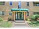Inviting apartment entrance with a green awning and well-maintained landscaping at 2100 N Franklin St # 8, Denver, CO 80205