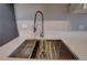 Close-up of a stainless steel kitchen sink with modern fixtures and a white countertop, offering a clean and functional space at 2100 N Franklin St # 8, Denver, CO 80205