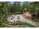 Backyard with beautiful landscaping, stone patio, deck, and comfortable seating, perfect for outdoor entertaining at 1456 Shavano Ct, Evergreen, CO 80439