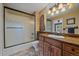 Bathroom features a shower/tub combo with sliding glass doors and marble vanity with a sink and wood cabinets at 1456 Shavano Ct, Evergreen, CO 80439