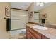 Bathroom features a shower/tub combo with sliding glass doors and marble vanity with a sink and wood cabinets at 1456 Shavano Ct, Evergreen, CO 80439