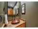 Charming powder room with a copper sink, granite countertop, and decorative mirror at 1456 Shavano Ct, Evergreen, CO 80439