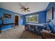 Blue bedroom with window overlooking trees and a door to the closet at 1456 Shavano Ct, Evergreen, CO 80439