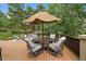 Outdoor deck area featuring a dining table with an umbrella and comfortable seating with backyard views at 1456 Shavano Ct, Evergreen, CO 80439