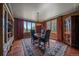 Dining room featuring hardwood floors, a wooden table with black chairs, and scenic views through large windows at 1456 Shavano Ct, Evergreen, CO 80439