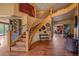 Grand foyer features hardwood floors, curved staircase, and views of dining room and living spaces at 1456 Shavano Ct, Evergreen, CO 80439
