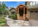 Close-up of a home's front entrance with stone pillars, wood accents, and landscaped walkway at 1456 Shavano Ct, Evergreen, CO 80439