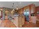 The kitchen features an island with barstool seating, stone archway, stainless steel appliances, and wood cabinetry at 1456 Shavano Ct, Evergreen, CO 80439