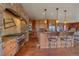 Kitchen boasts custom cabinetry, a stone archway, stainless steel appliances, and an island with barstool seating at 1456 Shavano Ct, Evergreen, CO 80439