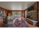 Cozy living room with wood floors, stone fireplace, and large windows with views of the backyard at 1456 Shavano Ct, Evergreen, CO 80439