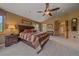 Cozy primary bedroom featuring large windows with wooded views, ceiling fan, and attractive decor at 1456 Shavano Ct, Evergreen, CO 80439