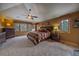 Cozy primary bedroom featuring large windows with wooded views, ceiling fan, and attractive decor at 1456 Shavano Ct, Evergreen, CO 80439