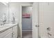 Bathroom with a vanity, sink, and a view of an adjacent room with a mounted art piece at 5928 N Odessa St, Aurora, CO 80019