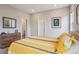 Bright bedroom with a yellow patterned bedspread, dresser and ensuite bathroom entrance at 5928 N Odessa St, Aurora, CO 80019