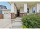Inviting front porch with classic brick accents and sturdy white columns near a two-car garage at 5928 N Odessa St, Aurora, CO 80019
