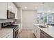 Modern kitchen featuring white cabinets, stainless steel appliances, and a stylish island with pendant lighting at 5928 N Odessa St, Aurora, CO 80019