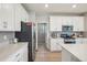 Bright kitchen showcasing white cabinetry, stainless steel appliances, and gray subway tile backsplash at 5928 N Odessa St, Aurora, CO 80019