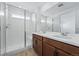 Bright bathroom featuring a double sink vanity and a glass-enclosed shower with a built-in seat at 3334 N Catawba Way, Aurora, CO 80019