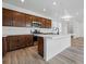 Modern kitchen with stainless steel appliances, dark wood cabinets, and a white countertop island at 3334 N Catawba Way, Aurora, CO 80019
