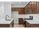 Bright kitchen featuring stainless steel appliances, white countertops, and dark wood cabinetry at 3334 N Catawba Way, Aurora, CO 80019