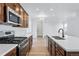 Modern kitchen with stainless steel appliances, white countertops, and brown cabinets at 3334 N Catawba Way, Aurora, CO 80019
