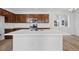 Modern kitchen featuring dark wood cabinets, white countertops, and an island with a sink at 3334 N Catawba Way, Aurora, CO 80019