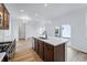 Open-concept kitchen featuring an island with a sink, stainless steel appliances, and hardwood floors at 3334 N Catawba Way, Aurora, CO 80019