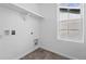 Laundry room featuring tile floor, white walls, shelf, window, and washer/dryer hookups at 3334 N Catawba Way, Aurora, CO 80019