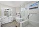 Bright bathroom with double vanity, soaking tub, and glass-enclosed shower with modern fixtures at 1053 Snow Lily Ct, Castle Pines, CO 80108