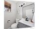 Well-lit half bathroom features a modern vanity and a decorative mirror at 1053 Snow Lily Ct, Castle Pines, CO 80108