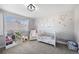 Adorable Bedroom with floral wall decals, soft armchair, and organized bookshelves at 1053 Snow Lily Ct, Castle Pines, CO 80108