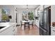 Bright breakfast nook with large windows and a table, next to modern kitchen with stainless steel fridge and custom cabinets at 1053 Snow Lily Ct, Castle Pines, CO 80108
