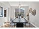 Elegant dining room featuring a modern light fixture, large windows, and sleek table setting for a sophisticated dining experience at 1053 Snow Lily Ct, Castle Pines, CO 80108