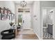 Bright entryway featuring modern decor, a statement light fixture, and a convenient half-bathroom at 1053 Snow Lily Ct, Castle Pines, CO 80108