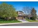 Two-story home with mature trees, a well-manicured lawn, and a two-car garage at 1053 Snow Lily Ct, Castle Pines, CO 80108