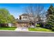 Charming two-story home with a well-manicured lawn, mature trees, and a two-car garage at 1053 Snow Lily Ct, Castle Pines, CO 80108